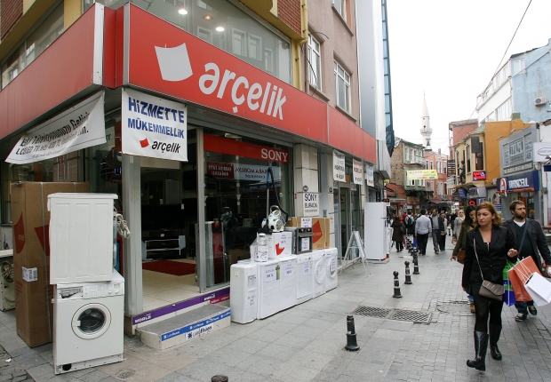 أشخاص يمشون أمام متجر يبيع غسالات وثلاجات في اسطنبول