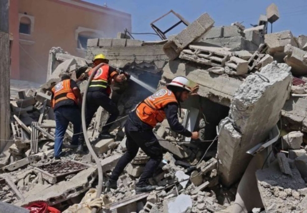 طواقم من الدفاع المدني تتفقد منزلا مدمرا بغزة-أرشيفية