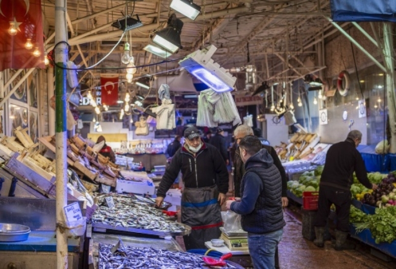 بائع يخدم أحد العملاء في كشك لتجار الأسماك في سوق محلي في بورصة